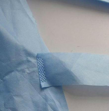 El hospital disponible no absorbente friega el vestido del laboratorio con el puño hecho punto